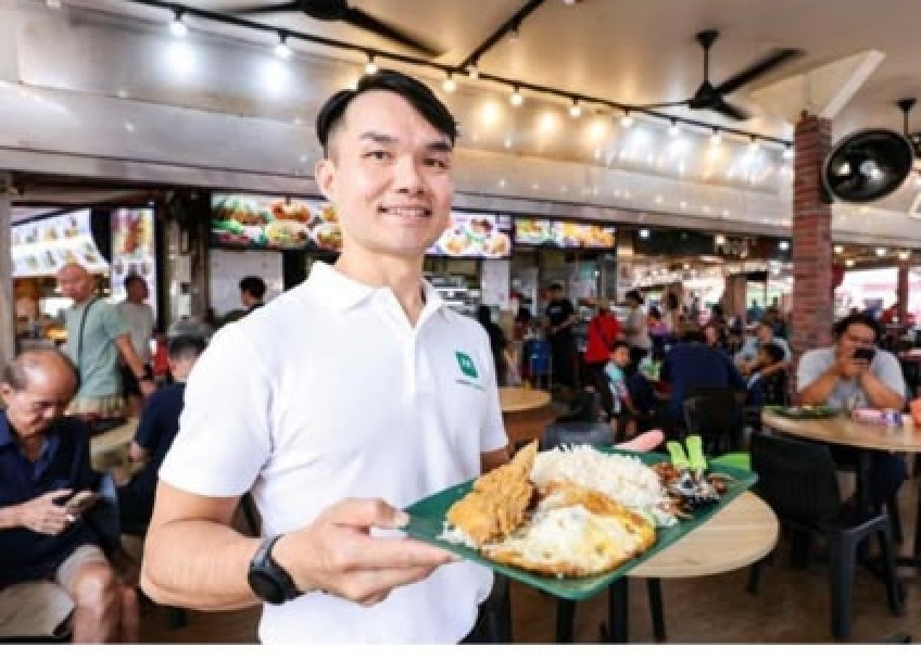 LeanerTogether founder Tan Chin Hock holding a tray of nasi lemak at a hawker centre