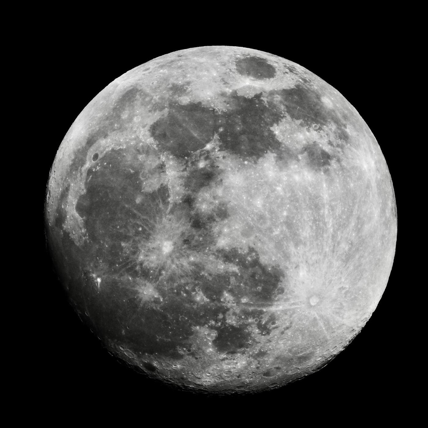 Close-up of the moon showing craters and maria in sharp detail, captured through a smartphone telephoto zoom